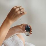 スキンケア美容液のボトルを手に取る様子